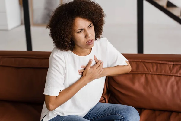 Heart panic attack disease of african american woman. Symptoms of angina pectoris. Attractive sick black girl with heart ilness infarkt