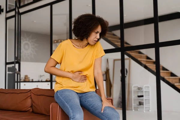 Ulcer or gastritis stomach ache. Sick african american girl hold abdomen because it hurts. Pancreatitis disease of pancreas becomes inflamed