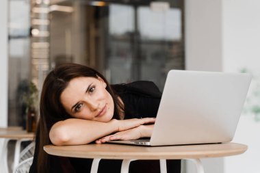 Uykucu ve yorgun kız ofiste fazla mesai yapıyor ve mola veriyor. İnternette fazla mesai yapıyorum. İş kadını işte uyumak istiyor.