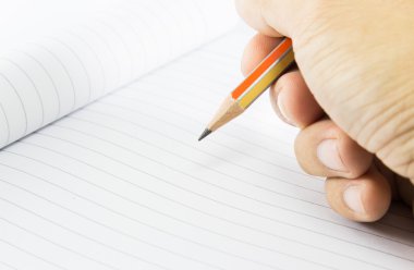 el üstünde defter kalem ile