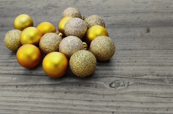 Bolas de Natal douradas em um fundo de madeira — Fotografia de Stock