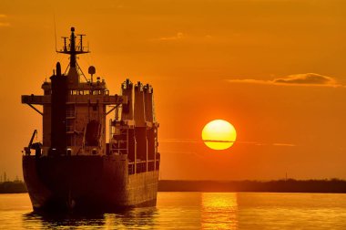 Gemi gün batımının arka planında yol kenarında duruyor.