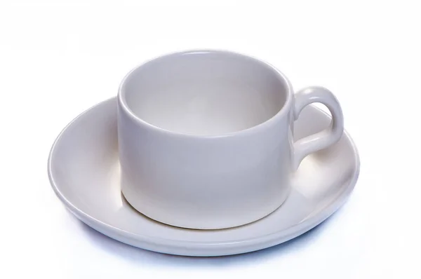 Biały kubek kawy ze spodkiem na białym, izolowanym tle — Zdjęcie stockowe