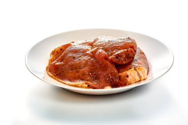 Salamura edilmiş domuz eti beyaz bir tabakta, izole edilmiş beyaz bir arka planda yatıyor.