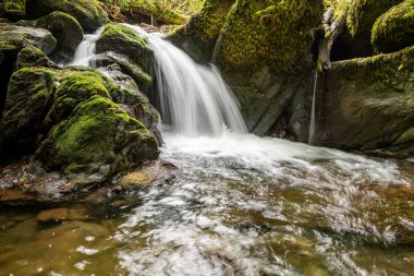 Hoar Oak Nehri 'nin üzerinde Exmoor Ulusal Parkı' ndaki Watersmeet 'te akan şelalenin uzun pozu.