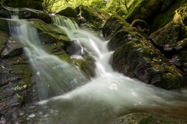 Hoar Oak Nehri 'nin üzerinde Exmoor Ulusal Parkı' ndaki Watersmeet 'te akan şelalenin uzun pozu.