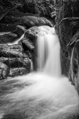 Hoar Oak Nehri 'nin üzerinde Exmoor Ulusal Parkı' ndaki Watersmeet 'te akan şelalenin uzun pozu.