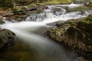 Doğu Lyn nehrinin üzerinde Exmoor Ulusal Parkı 'ndaki Watersmeet' te akan şelalenin uzun pozu