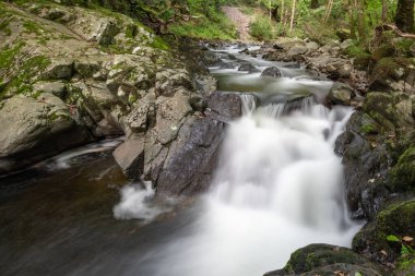 Doğu Lyn nehrinin üzerinde Exmoor Ulusal Parkı 'ndaki Watersmeet' te akan şelalenin uzun pozu