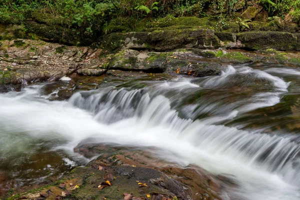 Lång Exponering Ett Vattenfall East Lyn Floden Rinner Genom Skogen — Stockfoto