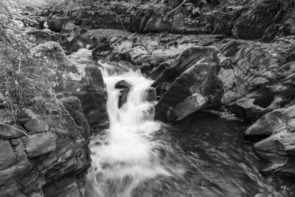 埃克斯莫尔国家公园内水流过森林的东连河上的瀑布长期暴露在水面上 — 图库照片