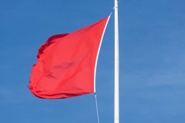 Rüzgarda dalgalanan kırmızı bayrağa yaklaş 