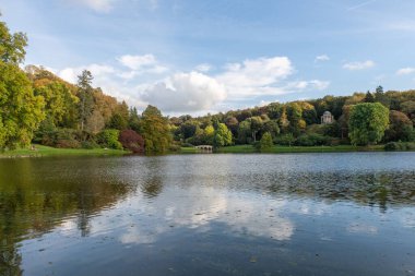 Wiltshire 'daki Stourhead bahçesindeki gölün etrafındaki sonbahar renklerinin görüntüsü