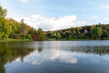 Wiltshire 'daki Stourhead bahçesindeki gölün etrafındaki sonbahar renklerinin görüntüsü