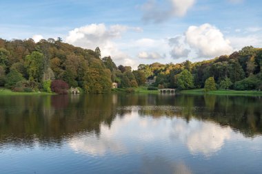 Wiltshire 'daki Stourhead bahçesindeki gölün etrafındaki sonbahar renklerinin görüntüsü