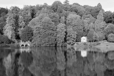 Stourhead 'deki gölün ve Wiltshire' daki bahçelerin siyah beyaz fotoğrafı.