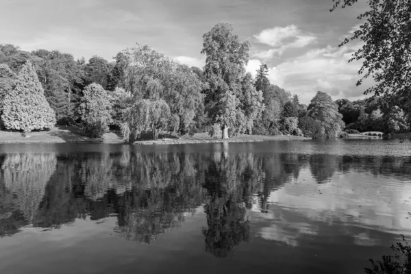Stourhead 'deki gölün ve Wiltshire' daki bahçelerin siyah beyaz fotoğrafı.
