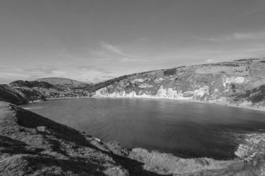 Dorset 'teki Jurassic Sahili' ndeki Lulworth Koyu 'nun siyah beyaz fotoğrafı.