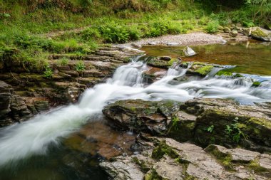 Watersmeet Köprüsü Şelalesi 'nin doğu Lyn Nehri üzerindeki Exmoor Ulusal Parkı' ndaki Watersmeet Nehri 'nde uzun süre görüldü.