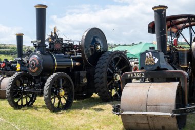 Batı Bay.Dorset.Birleşik Krallık. 12 Haziran 2022 Bir sıra tamir edilmiş çekme motoru ve buhar silindiri West Bay vintage rallisinde sergileniyor.
