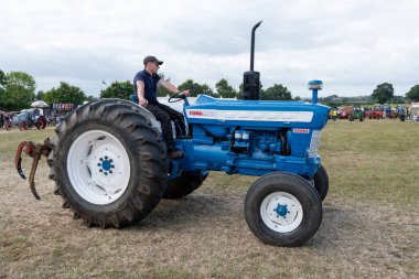 Ilminster. Somerset. Birleşik Krallık. 21 Ağustos 2022 Yenilenmiş bir Ford 5000 traktörü dün geceki bir çiftçilik etkinliğinde arenada kullanılıyor.