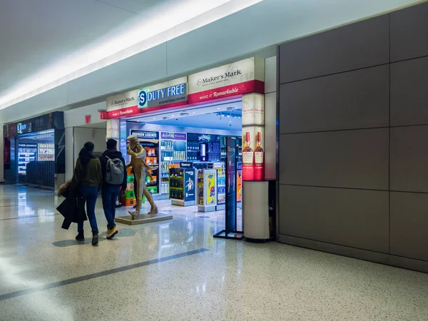 New York, USA - December 25, 2021: Horizontal Side View of the Duty Free Shop of Terminal 5 of the John F. Kennedy International Airport with Travelers Walking by.