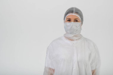 Doktor ya da hemşire tıbbi önlük, maske ve koruyucu eldiven giyer.