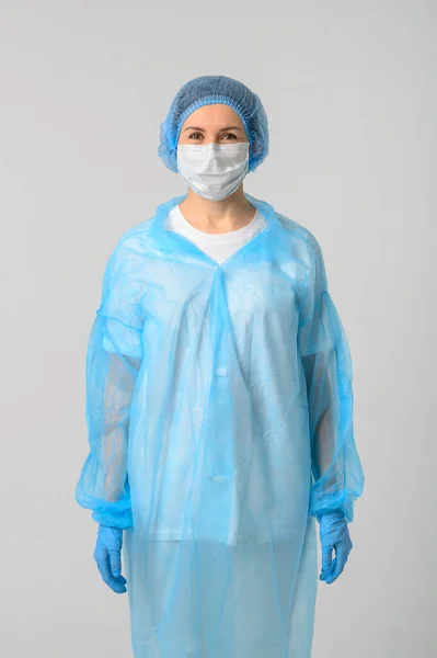 Doctor or nurse in a medical gown, mask and protective gloves — Stock Photo, Image