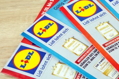 Hamburg, Almanya - 21 Kasım 2021: Prospekte mit Angeboten von Lidl auf Holz - Lidl 'den ahşap üzerine broşürler