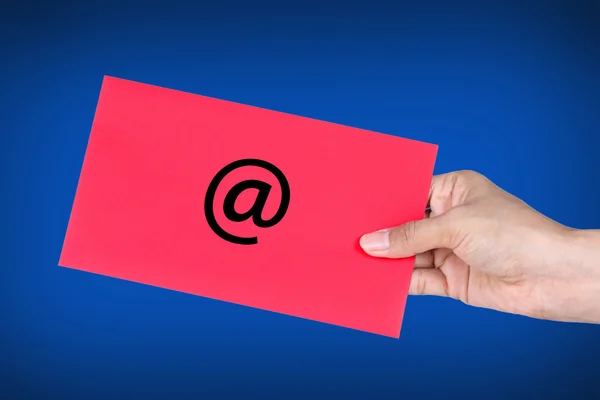 Mano sosteniendo sobre rojo con en Símbolo, concepto de E-Mail — Foto de Stock