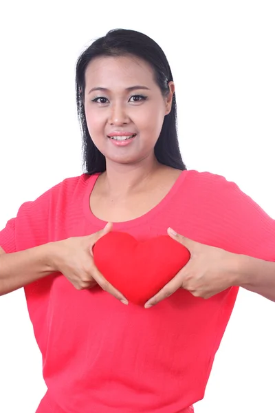 Junge Frau hält ein Herz geformt roten Kissen, isoliert auf weiss — Stock fotografie