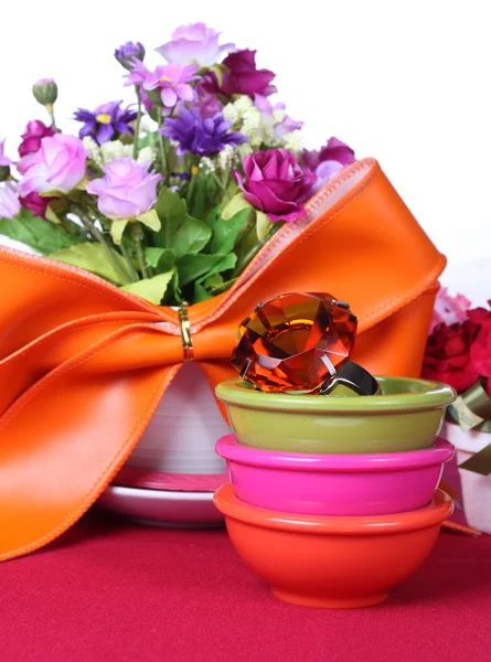 Topaz ring in a bowl with colorful artificial flower — Stock Photo, Image