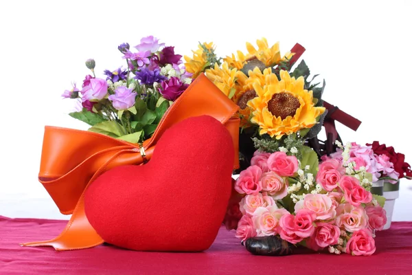 Červené srdce s barevné umělé květiny — Stock fotografie