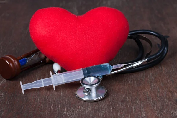 Медицинская, группа предметов на деревянном столе. красное сердце, стетоскоп , — стоковое фото