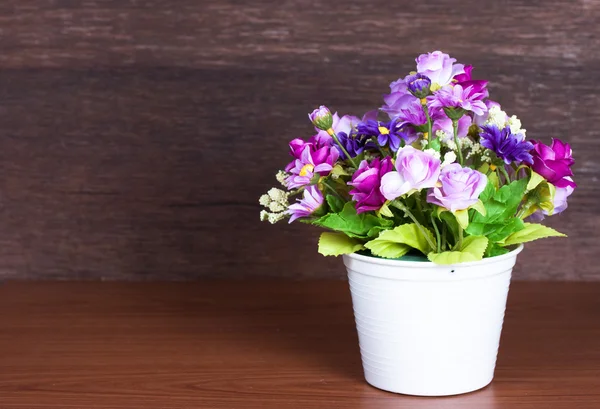 Bunte künstliche Blume auf Holz Hintergrund — Stockfoto