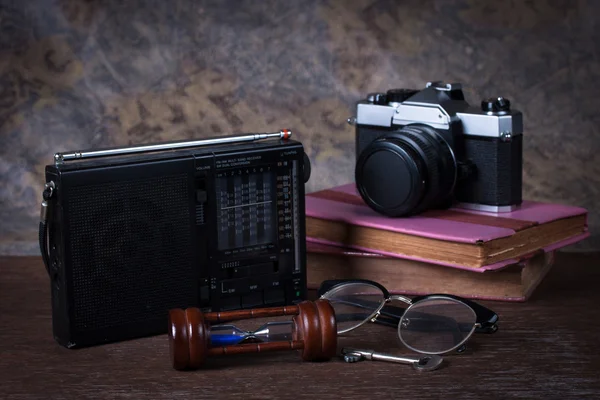 Group of objects on wood table. hourglass, key, retro radio, cam — Stock Photo, Image