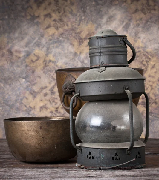 Old rusty kerosene lamp with copper bowl on wood background. — Stock Photo, Image