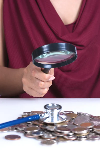 Finansiella begrepp, hand hålla förstoringsglas och mynt — Stockfoto