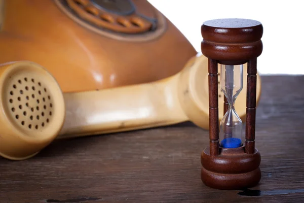 Hourglass and old telephone — Stock Photo, Image