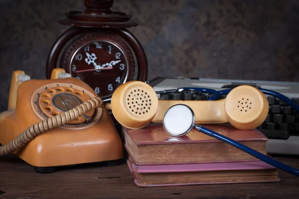 Stéthoscope, vieux téléphone, vieille horloge, machine à écrire — Photo