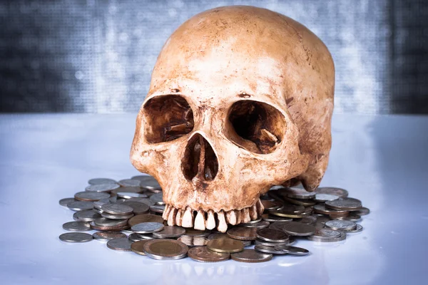 Weathered human skull and coins — Stock Photo, Image