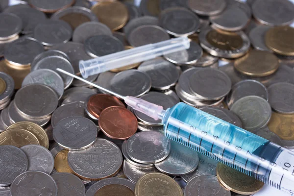 Финансовая концепция, шприц с монетами — стоковое фото