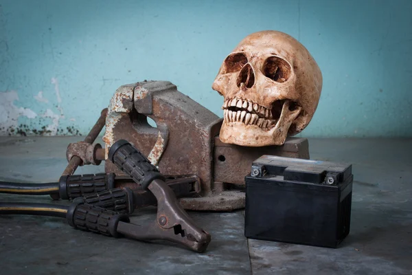 人間の頭蓋骨、ベンチ万力、ジャンパー ケーブル ロイヤリティフリーのストック写真