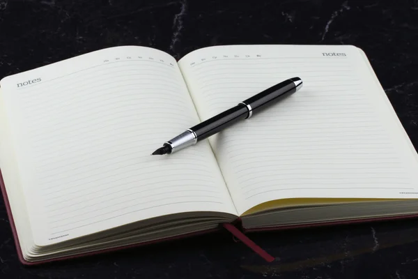 Pluma y cuaderno negro — Foto de Stock