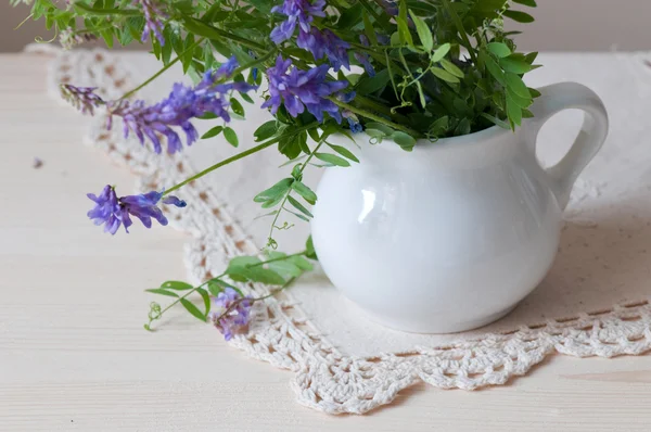 Flores violetas selvagens em vaso branco — Fotografia de Stock