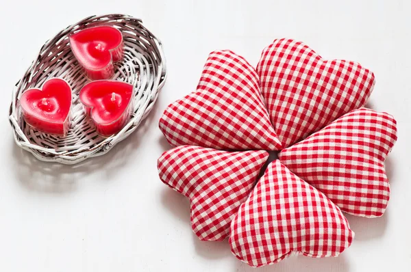 Red valentine's hearts with candes in a white basket — Stock Photo, Image