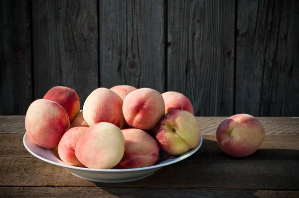 eski ahşap masa üzerinde şeftali ile kase