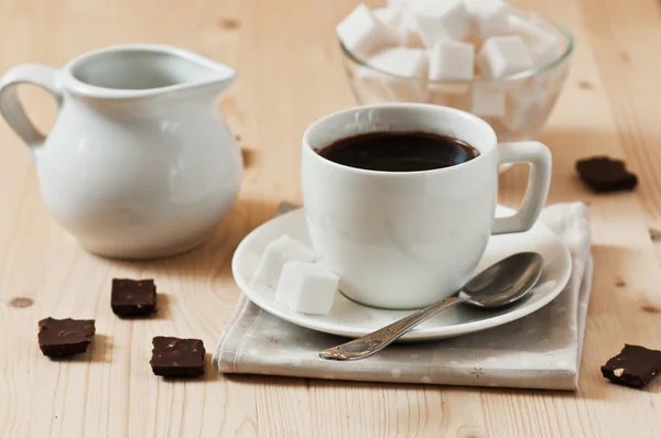 Tazza bianca di caffè con cioccolato e zucchero in tavolo di legno — Foto Stock