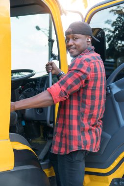 truck driver smiling confident in insurance cargo lorry In long transportation and delivery business. young African-American man training driving commercial driver license at truck driving school.