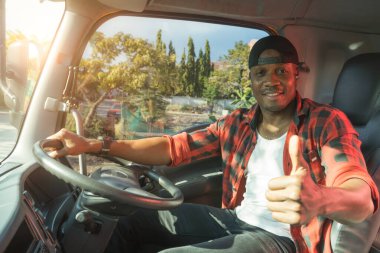 professional truck driver delivery worker in transportation and delivery business for long time.Young African American man smiling positive confident thumbs up in truck cargo insurance service. 